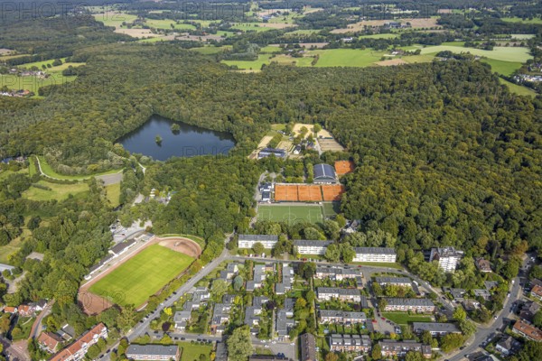 Aerial view, football stadium Am Freibad TV Jahn Hiesfeld, Rotbachsee in the forest, tennis courts and facilities Reitverein und Fahrverein 1946 e.V., Housing estate on Dorfstraße, Hiesfeld, Dinslaken, Ruhr area, North Rhine-Westphalia, Germany, DE, Europe, football, football pitch, football stadium, property tax, Hanseatic city, real estate, aerial view, aerial photography, aerial photography, Lower Rhine, equestrian sports, equestrian centre, equestrian centre, equestrian sports, equestrian centre, equestrian club, sports, sports centre, sports field, tennis, tennis centre, tennis court, tennis courts, tennis club, overview, bird's-eye view, residential area, residential area and living, residential area, residential quality, residential area, residential estate, residential district, birds-eyes view, overview