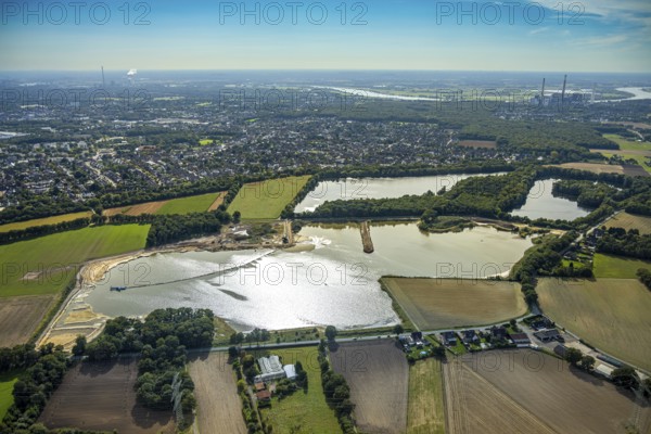 Aerial view, Schwarzer Weg quarry pond, view of Voerde and Voerde power station, Bruckhausen, Hünxe, Ruhr area, North Rhine-Westphalia, Germany, DE, Europe, distant view, aerial view, aerial photography, aerial photography, Lower Rhine, lake, overview, bird's eye view, birds-eyes view, blue sky, overview
