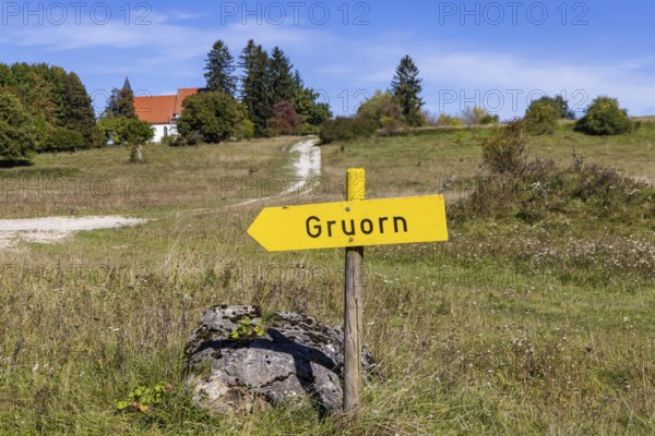 Gruorn is a deserted village near Münsingen in the Swabian Alb. The former village is located in the former military training area and has been part of the newly established Swabian Alb biosphere reserve since 2008. Landscape with signpost and St Stephen's Church. Münsingen, Baden-Württemberg, Germany