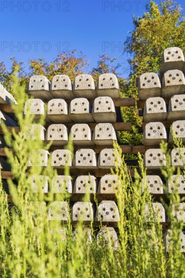Many stacked concrete blocks with plants in the foreground, Hermann Hessebahn construction site, Calw, Germany
