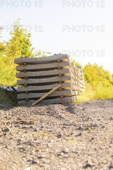 Stacked concrete sleepers under bright sunlight, Hermann Hessebahn construction site, Calw, Germany