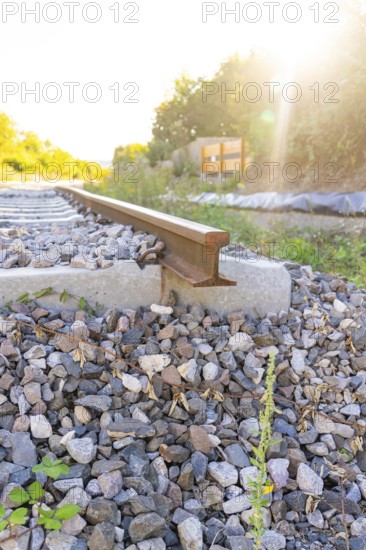 Close-up of a railway track in sunlight on ballast, Hermann Hessebahn construction site, Calw, Germany