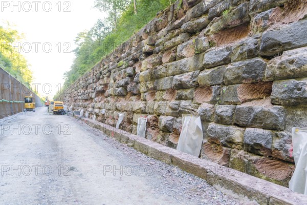 Long rock wall along a dusty construction site path, Hermann Hessebahn construction site, Calw, Germany