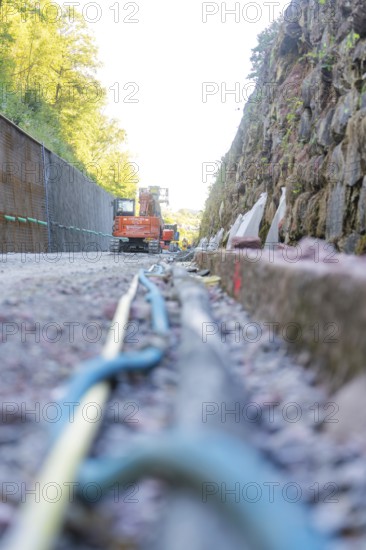 Cable and rock wall on a construction site with construction machinery, Hermann Hessebahn construction site, Calw, Germany