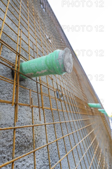 Close-up of a concrete wall with wire mesh and green pipes, Hermann Hessebahn construction site, Calw, Germany