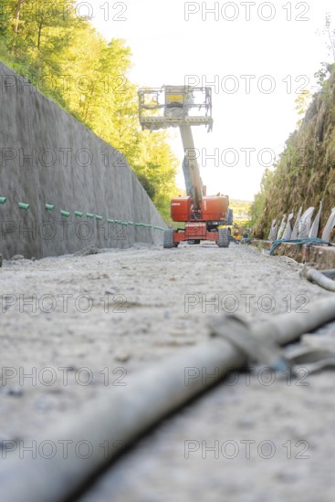On a construction site, a working platform lifts between concrete walls in the forest, Hermann Hessebahn construction site, Calw, Germany