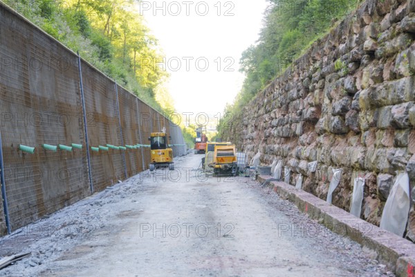Abandoned construction site with equipment in a narrow street flanked by stone walls, Hermann Hessebahn construction site, Calw, Germany