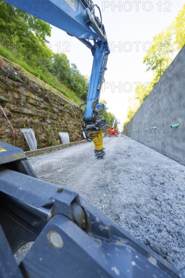 Close-up of crane arm on construction site, surrounded by concrete wall and trees, Hermann Hessebahn construction site, Calw, Germany