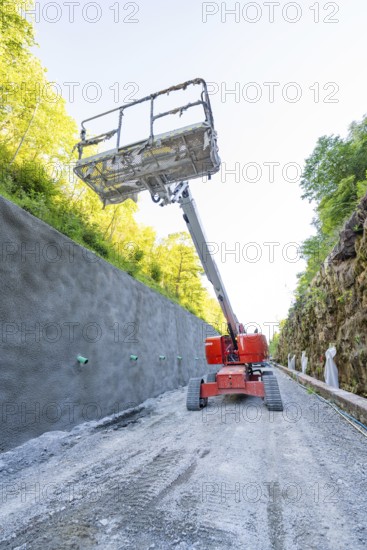 Lifting platform rises in front of concrete wall on construction site in the forest, Hermann Hessebahn construction site, Calw, Germany