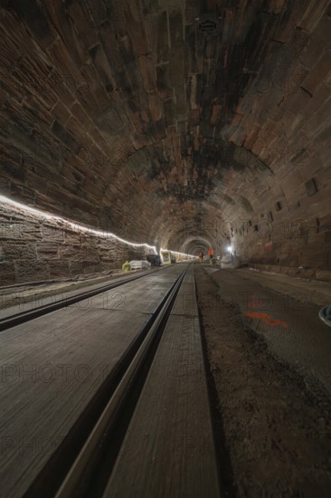 Dark tunnel with rails and lighting along the tunnel walls, construction of the Hermann Hesse railway, Calw, Black Forest, Germany