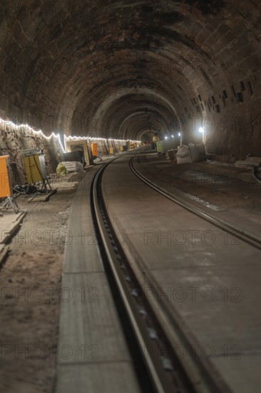 An illuminated railway tunnel, partly construction site with visible brick walls, construction of the Hermann Hesse railway, Calw, Black Forest, Germany