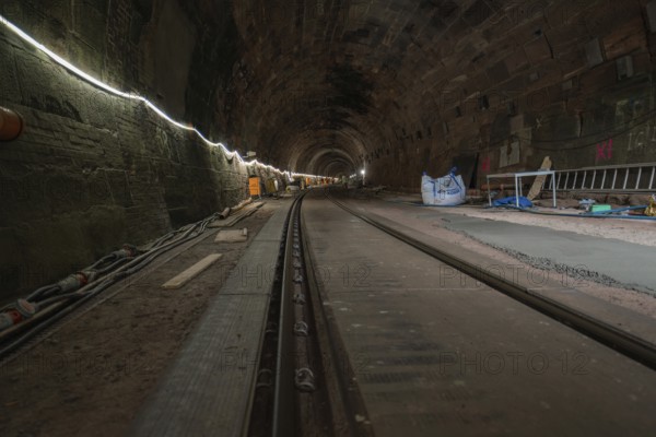 A tunnel with stone walls and railway tracks, illuminated and with building accessories, construction of the Hermann Hesse railway, Calw, Black Forest, Germany