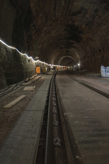 Long stone tunnel with lighting and construction equipment along the track, construction of the Hermann Hesse railway, Calw, Black Forest, Germany