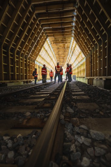 Groups of workers in a wooden railway tunnel, illuminated from the inside, construction of the Hermann Hesse railway, Calw, Black Forest, Germany