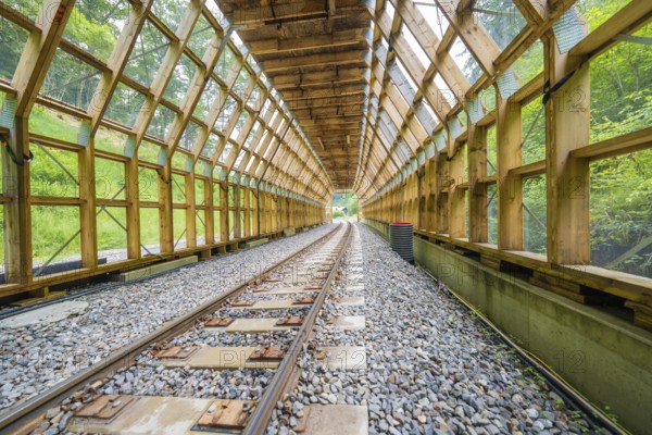An open tunnel with a view of a green environment and an illuminated interior, construction of the Hermann Hesse railway, Calw, Black Forest, Germany