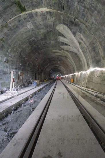 An unfinished tunnel with rails, in a dark, rough construction site environment, construction of the Hermann Hesse railway, Calw, Black Forest, Germany
