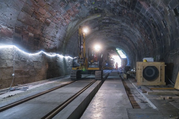A large machine is used for construction work in the structured tunnel. Rails and wood are visible, construction of the Hermann Hesse railway, Calw, Black Forest, Germany