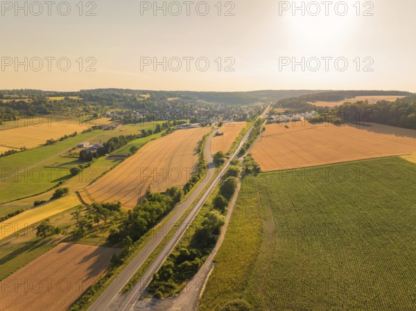 Natural landscape with fields and village, taken from above, illuminated by the sunset, construction of the Hermann Hesse railway, Calw, Black Forest, Germany