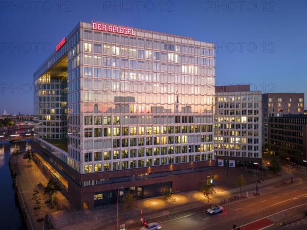 Aerial view of the Spiegel building with glass façade and illuminated offices at blue hour, Hamburg, Germany