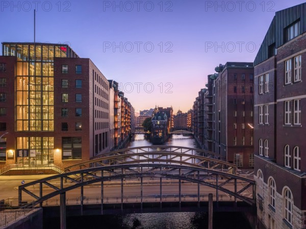 Evening shot of Hamburg's Speicherstadt warehouse district with a view of the moated castle and the Poggenmühlenbrücke bridge at the blue hour, Hamburg, Germany