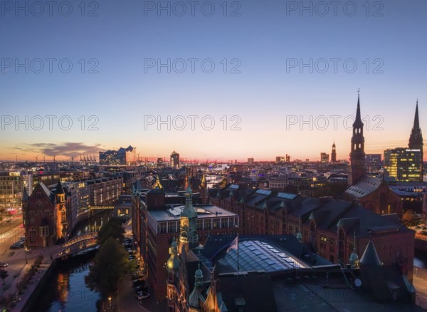Aerial view of Hamburg's Speicherstadt warehouse district at sunset with a view of the Elbphilharmonie concert hall, St Katharinen and the main church of St Nikolai, Hamburg, Germany