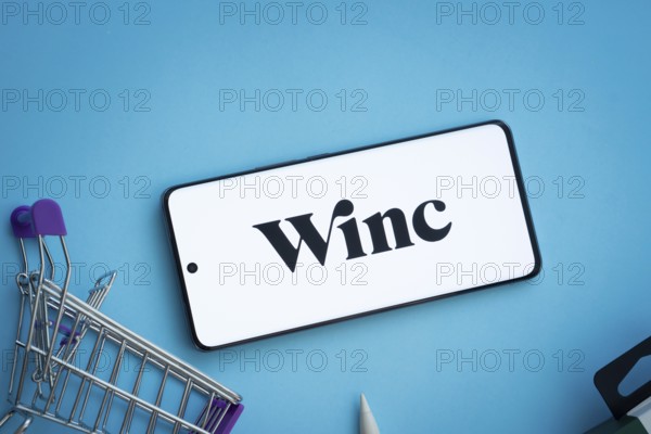 Dhaka, Bangladesh- 03 July 2025: Smartphone displaying Winc logo with shopping cart on a blue background