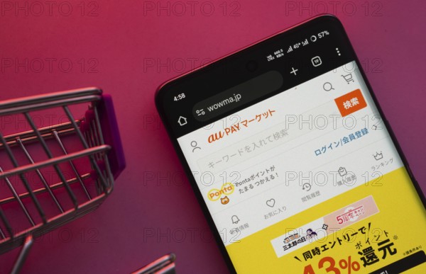 Dhaka, Bangladesh- 23 June 2025: A smartphone displaying the wowma website with a shopping cart is shown on a vibrant background