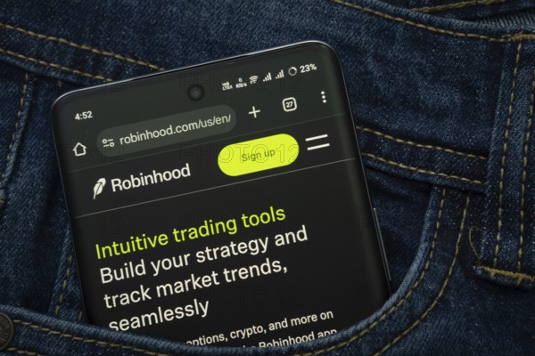 Dhaka, Bangladesh- 15 June 2025: A smartphone displaying the Robinhood web interface peeks out of a denim pocket