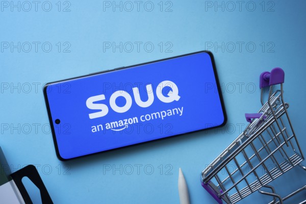 Dhaka, Bangladesh- 03 July 2025: Smartphone displaying Souq logo with shopping cart on a blue background