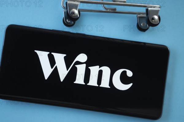 Dhaka, Bangladesh- 03 July 2025: Smartphone screen showing the Winc logo with shopping cart wheels on a blue background