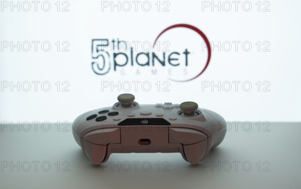 Dhaka, Bangladesh- 23 Sep 2025: Game controller in front of 5th planet games logo on a blue background