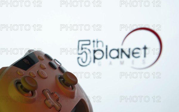 Dhaka, Bangladesh- 23 Sep 2025: A close-up of a gamepad with the 5th planet games seen on screen in the background