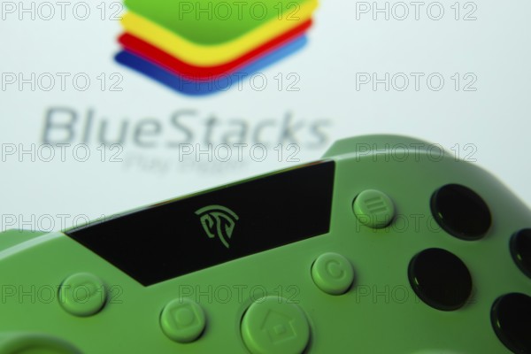 Dhaka, Bangladesh- 23 Sep 2025: A close-up of a gamepad with the BlueStacks seen on screen in the background