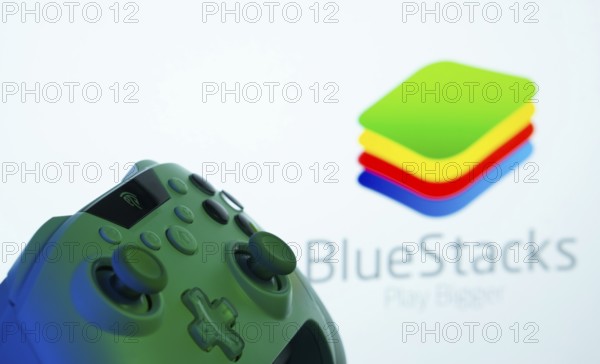Dhaka, Bangladesh- 23 Sep 2025: A close-up of a gamepad with the BlueStacks seen on screen in the background