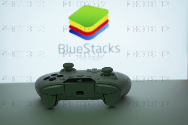 Dhaka, Bangladesh- 23 Sep 2025: Game controller in front of BlueStacks logo on a background