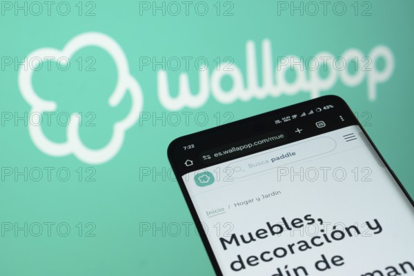 Dhaka, Bangladesh- 03 July 2025: Smartphone displaying Wallapop web interface against wallapop logo background