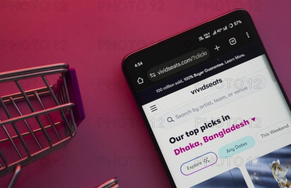 Dhaka, Bangladesh- 23 June 2025: A smartphone displaying the VividSeats website with a shopping cart is shown on a vibrant background