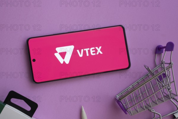 Dhaka, Bangladesh- 03 July 2025: Smartphone displaying VTEX logo alongside a shopping cart on a purple background