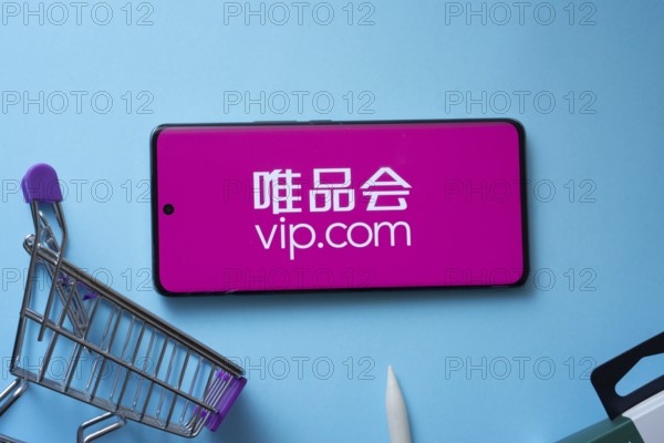 Dhaka, Bangladesh- 03 July 2025: Smartphone displaying vip.com logo with shopping cart on a blue background
