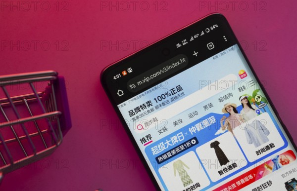 Dhaka, Bangladesh- 23 June 2025: A smartphone displaying the vip.com website with a shopping cart is shown on a vibrant background