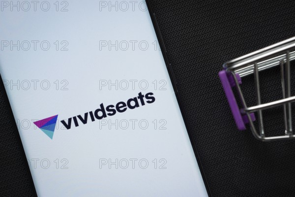 Dhaka, Bangladesh- 03 July 2025: A smartphone displaying the VividSeats logo next to a miniature shopping cart on a background