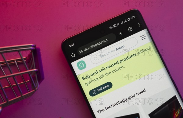 Dhaka, Bangladesh- 23 June 2025: A smartphone displaying the Wallapop website with a shopping cart is shown on a vibrant background