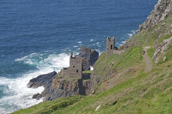 Ruins on craggy cliffs offer breathtaking views of the turbulent sea below, engine room of an old copper mine, Cornwall, United Kingdom