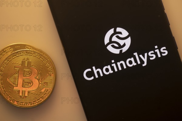 A Bitcoin coin next to a Chainalysis logo on a black background