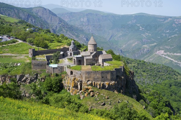 An ancient monastery sits majestically on a hill overlooking a mountainous landscape, Tatev Monastery, Tatev, Armenian Apostolic Monastery, Syunik Province, Syunik, Armenia