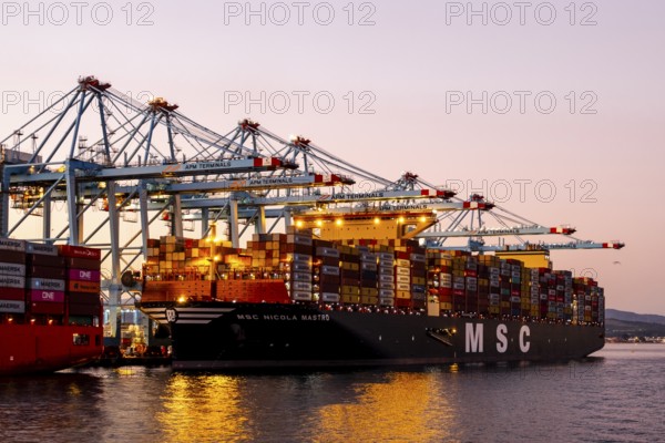 Gibraltar, UK - December 26, 2023: Container ship in the port during sunset