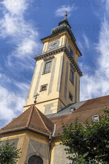 Baroque church tower with clock against a blue sky with light clouds, Old Town Linz Upper Austria Austria
