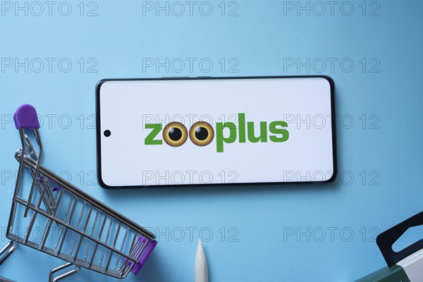 Dhaka, Bangladesh- 03 July 2025: Smartphone displaying zooplus logo with shopping cart on a blue background