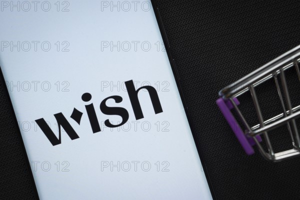 Dhaka, Bangladesh- 03 July 2025: A smartphone displaying the Wish logo next to a miniature shopping cart on a background