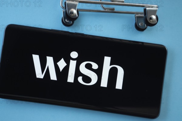 Dhaka, Bangladesh- 03 July 2025: Smartphone screen showing the Wish logo with shopping cart wheels on a blue background